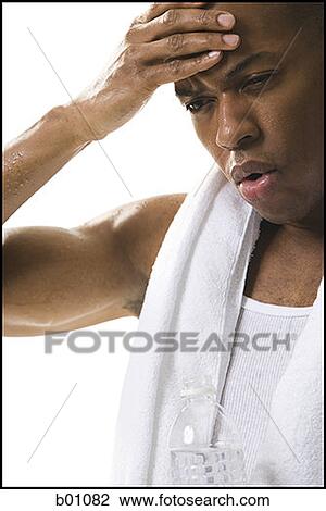 Close-up of a young man touching his forehead View Large Photo Image Stock Image - Close-up of a young man touching his forehead. Fotosearch