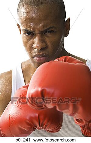 Stock Image - Close-up of a young man wearing boxing gloves. Fotosearch