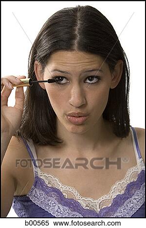 Close-up of a young woman applying mascara View Large Photo Image Stock Photography - Close-up of a young woman applying mascara. Fotosearch