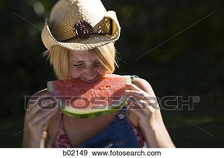 Close-up of a young woman biting a piece of watermelon View Large Photo Image Stock Photo - Close-up of a young woman biting a piece of watermelon. Fotosearch