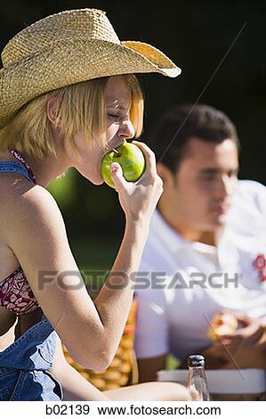 Close-up of a young woman biting an apple View Large Photo Image Stock Photo - Close-up of a young woman biting an apple. Fotosearch