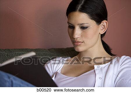 Close-up of a young woman reading a book View Large Photo Image Stock Image - Close-up of a young woman reading a book. Fotosearch