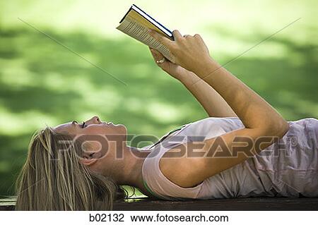 Close-up of a young woman reading a book in a park View Large Photo Image Stock Image - Close-up of a young woman reading a book in a park. Fotosearch