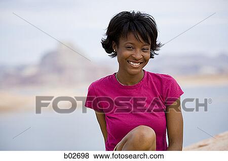 Close-up of a young woman smiling View Large Photo Image Stock Photo - Close-up of a young woman smiling. Fotosearch