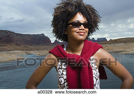 Stock Photo - Close-up of a young woman standing on a lakeside. Fotosearch