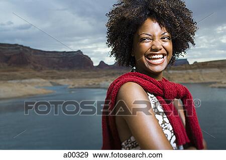 Close-up of a young woman standing on a lakeside View Large Photo Image Stock Photo - Close-up of a young woman standing on a lakeside. Fotosearch
