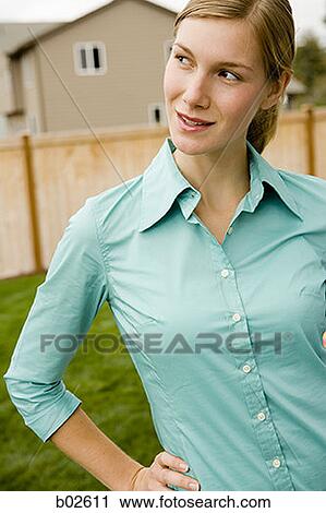 Close-up of a young woman standing View Large Photo Image Stock Image - Close-up of a young woman standing. Fotosearch