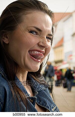 Close-up of a young woman sticking her tongue out View Large Photo Image Stock Photography - Close-up of a young woman sticking her tongue out. Fotosearch