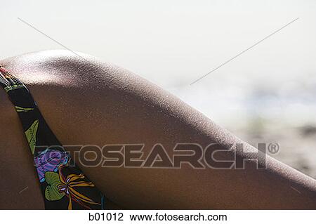 Close-up of a young woman sunbathing on the beach View Large Photo Image Stock Image - Close-up of a young woman sunbathing on the beach. Fotosearch