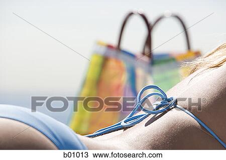 Close-up of a young woman sunbathing on the beach View Large Photo Image Stock Image - Close-up of a young woman sunbathing on the beach. Fotosearch