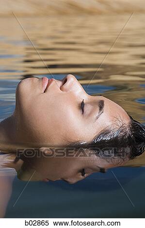 Close-up of a young woman swimming in water View Large Photo Image Stock Photography - Close-up of a young woman swimming in water. Fotosearch