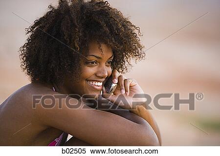 Close-up of a young woman talking on a mobile phone View Large Photo Image Stock Photography - Close-up of a young woman talking on a mobile phone. Fotosearch