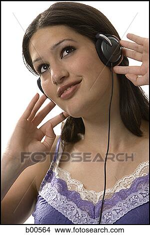 Close-up of a young woman wearing headphones and listening to music View Large Photo Image Picture - Close-up of a young woman wearing headphones and listening to music. Fotosearch