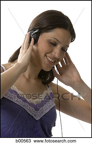 Close-up of a young woman wearing headphones and listening to music View Large Photo Image Stock Image - Close-up of a young woman wearing headphones and listening to music. Fotosearch