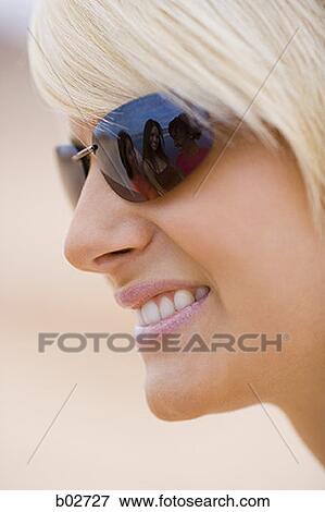 Close-up of a young woman wearing sunglasses View Large Photo Image Stock Photo - Close-up of a young woman wearing sunglasses. Fotosearch
