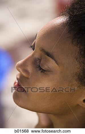 Close-up of a young woman with her eyes closed View Large Photo Image Stock Photo - Close-up of a young woman with her eyes closed. Fotosearch