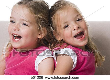 Close-up of girls sitting back to back on a couch View Large Photo Image Stock Photograph - Close-up of girls sitting back to back on a couch. Fotosearch