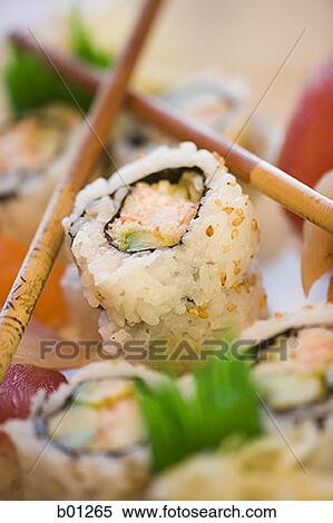 Stock Photography - Close-up of sushi rolls with chopsticks. Fotosearch