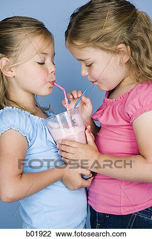 Close-up of two sisters sharing a milkshake View Large Photo Image Stock Image - Close-up of two sisters sharing a milkshake. Fotosearch