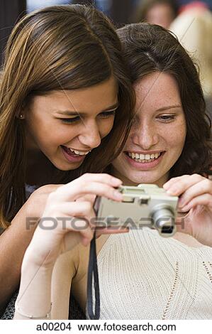 Close-up of two teenage girls looking at a camera screen View Large Photo Image Picture - Close-up of two teenage girls looking at a camera screen. Fotosearch
