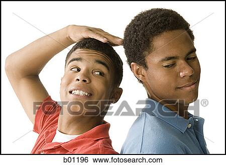 Close-up of two young men standing back to back View Large Photo Image Stock Photograph - Close-up of two young men standing back to back. Fotosearch