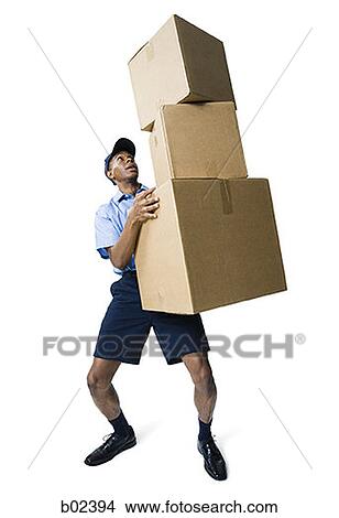 Delivery man holding a stack of boxes View Large Photo Image Picture - Delivery man holding a stack of boxes. Fotosearch