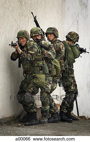 Stock Photograph - Four soldiers holding guns. Fotosearch