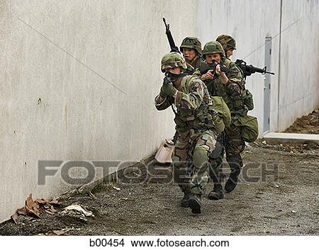 Four soldiers walking in a row aiming their rifles View Large Photo Image Picture - Four soldiers walking in a row aiming their rifles. Fotosearch