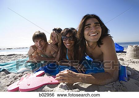 Stock Photograph - Four young people at the beach. Fotosearch