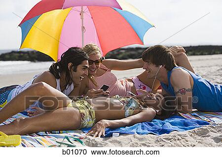 Four young people on the beach View Large Photo Image Stock Image - Four young people on the beach. Fotosearch