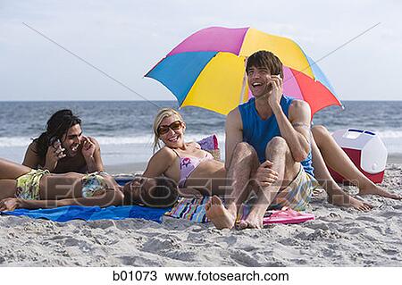 Four young people on the beach View Large Photo Image Stock Image - Four young people on the beach. Fotosearch