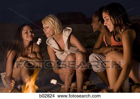 Four young women sitting at a campfire View Large Photo Image Picture - Four young women sitting at a campfire. Fotosearch