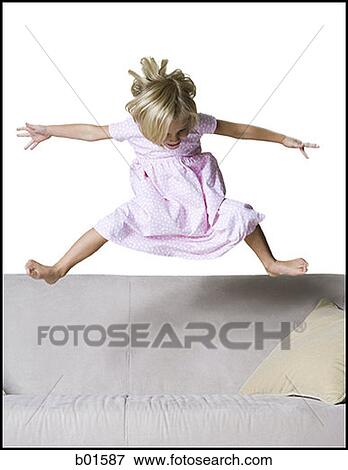 Girl jumping on a couch View Large Photo Image Stock Photo - Girl jumping on a couch. Fotosearch