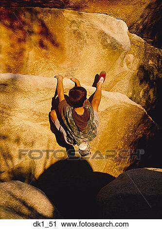 Stock Image - High angle view of a boy rock climbing. Fotosearch