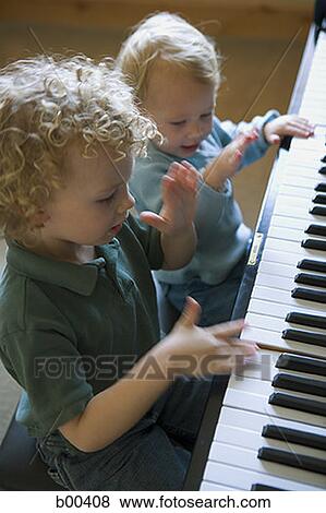 Stock Photo - High angle view of a brother and sister playing piano. Fotosearch