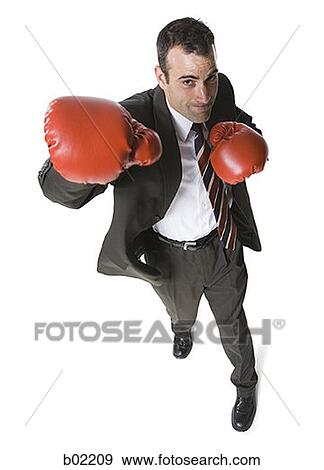 High angle view of a businessman wearing boxing gloves and punching View Large Photo Image Stock Photo - High angle view of a businessman wearing boxing gloves and punching. Fotosearch
