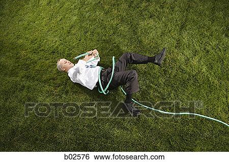 Stock Photograph - High angle view of a businessman playing with a hose. Fotosearch