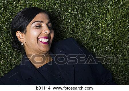 High angle view of a businesswoman lying on a lawn View Large Photo Image Picture - High angle view of a businesswoman lying on a lawn. Fotosearch