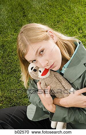 Stock Image - High angle view of a businesswoman hugging a toy. Fotosearch