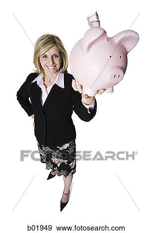 High angle view of a businesswoman holding up a piggy bank View Large Photo Image Stock Photo - High angle view of a businesswoman holding up a piggy bank. Fotosearch