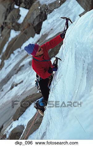 Stock Photograph - High angle view of a man climbing a snow covered mountain. Fotosearch