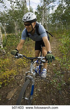 High angle view of a mature man cycling on a dirt road View Large Photo Image Stock Image - High angle view of a mature man cycling on a dirt road. Fotosearch