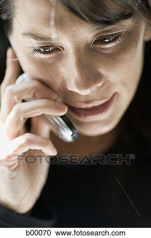 Stock Image - High angle view of a mid adult woman talking on the mobile phone. Fotosearch