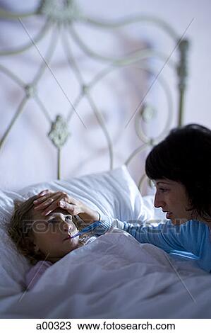 High angle view of a mother checking her daughter's temperature View Large Photo Image Stock Image - High angle view of a mother checking her daughter's temperature. Fotosearch