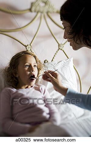 High angle view of a mother giving her daughter medicine View Large Photo Image Stock Photography - High angle view of a mother giving her daughter medicine. Fotosearch