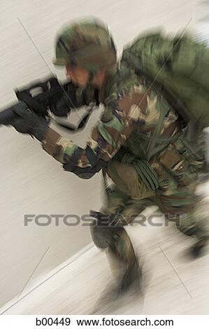 Stock Photo - High angle view of a soldier aiming his rifle. Fotosearch