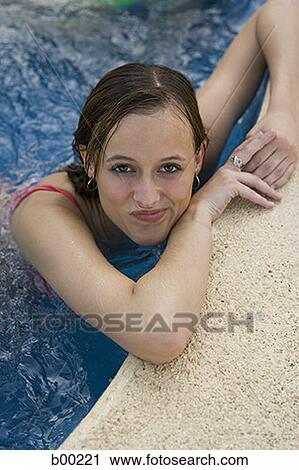 High angle view of a teenage girl leaning on the edge of a swimming pool View Large Photo Image Stock Image - High angle view of a teenage girl leaning on the edge of a swimming pool. Fotosearch