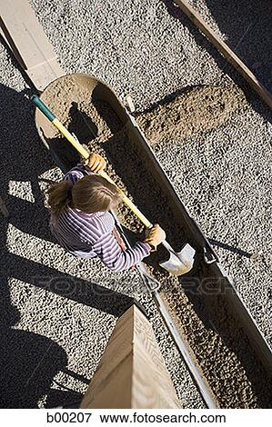High angle view of a worker pouring cement with a shovel View Large Photo Image Stock Photo - High angle view of a worker pouring cement with a shovel. Fotosearch
