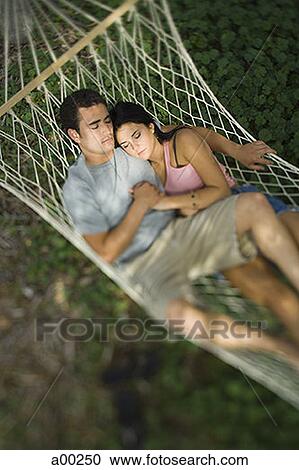 High angle view of a young couple lying on a hammock View Large Photo Image Stock Image - High angle view of a young couple lying on a hammock. Fotosearch