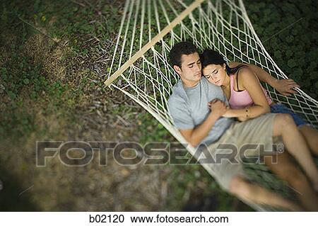 High angle view of a young couple sleeping in a hammock View Large Photo Image Stock Image - High angle view of a young couple sleeping in a hammock. Fotosearch